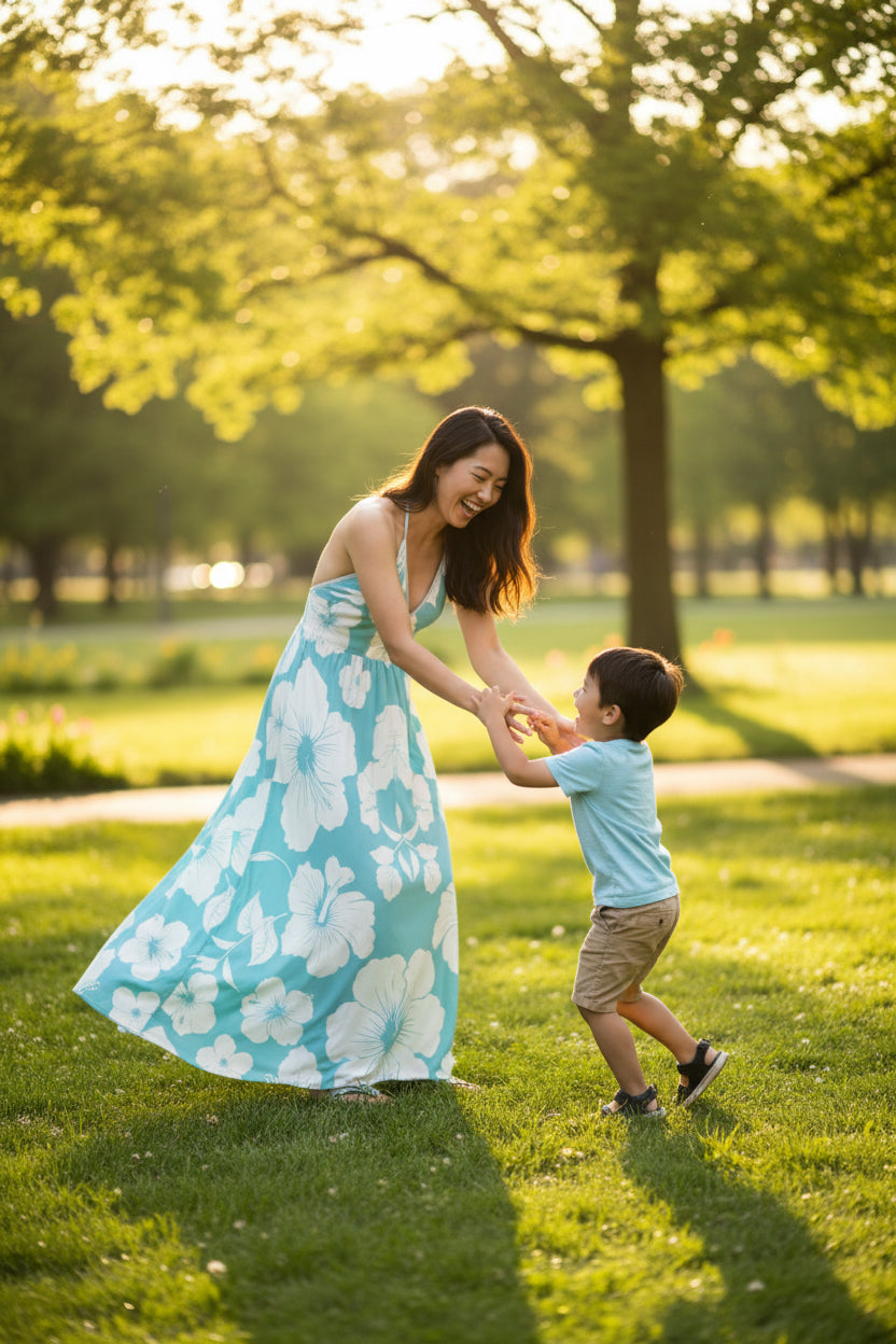 Asian woman playing with her son in the park wearing Blue and white dress covered in white hibiscus flowers