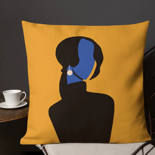 An abstract decorative pillow featuring a minimalist feminine silhouette in deep black with a vivid cobalt blue face and pearl earring, set against a warm golden background. The modern composition blends elegance, mystery, and contemporary gallery-inspired design.